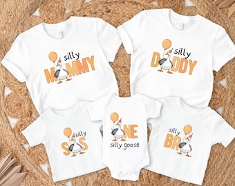 Könnte beinhalten: Vier weiße T-Shirts mit einem Gänse-Motiv und Text. Die Shirts sagen "silly mommy", "silly daddy", "silly sis" und "silly bro". Ein weißer Strampler mit einem Gänse-Motiv und Text, der "one silly goose" sagt.