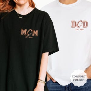May include: Two t-shirts, one black and one white, with a football design and the words "MOM" and "DAD" with the year "2025" underneath.
