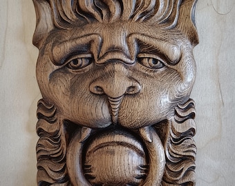 Paneel met leeuwenkopreliëf in massief eikenhout met een verouderde patina.