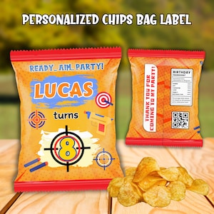Könnte beinhalten: Personalisierte Chipstüten-Etikett mit dem Text "READY... AIM... PARTY!" und "LUCAS turns 8". Die Tüte ist orange mit roter Umrandung und zeigt Zielscheiben- und Spielzeugpistolen-Grafiken. Ein Haufen Chips liegt vor der Tüte.