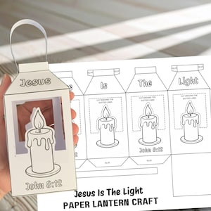 May include: A white paper lantern with a handle, featuring a candle design and the text "Jesus" and "John 8:12." A sheet with instructions and the text "Jesus Is The Light PAPER LANTERN CRAFT" is next to the lantern.