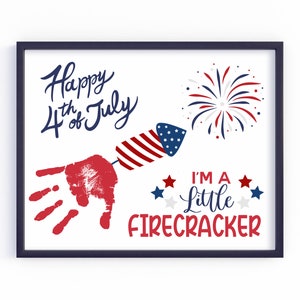 May include: A framed print featuring a red handprint and a firework design. The text reads "Happy 4th of July" and "I'm a little firecracker".