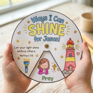 Op de afbeelding: Een kleurrijk, cirkelvormig knutselwerk met de tekst "Ways I Can SHINE for Jesus!". Het ontwerp bevat een vuurtoren, een biddend meisje, een kruis en een zaklamp. De tekst "Let your light shine before others. Matthew 5:16" is ook aanwezig.