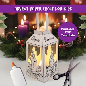 Op de afbeelding: Een witte papieren lantaarn met de woorden "Hope" en "Love" wordt van binnenuit verlicht, met kaars- en hulstontwerpen. De tekst "Advent Paper Craft for Kids" staat bovenaan. Een lijmfles en een schaar staan naast de lantaarn.