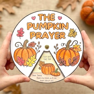 Może przedstawiać: Okrągła papierowa wycinanka zatytułowana The Pumpkin Prayer z ilustracjami pomarańczowych dyń, kolorowymi jesiennymi liśćmi i ruchomą trójkątną sekcją z tekstem Cut off the top oraz Dear Jesus, Open my mind, so I can learn about you.