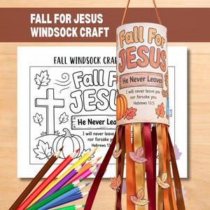 May include: A Fall for Jesus windsock craft kit featuring a printed paper cylinder with orange text, a pumpkin, and autumn leaves. The kit includes a black and white colouring sheet with a cross and pumpkin, plus coloured pencils and hanging ribbons.