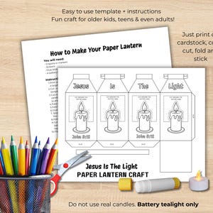 May include: A paper lantern craft kit with instructions. The design features a candle graphic and the text "Jesus Is The Light." Includes a pencil holder with colored pencils, scissors, and a battery-operated tealight.