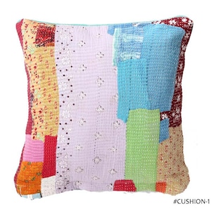 May include: A square patchwork cushion with a variety of fabrics in shades of red, yellow, pink, blue, and green. The cushion has a stitched design and the text "#CUSHION-1" in the bottom right corner.