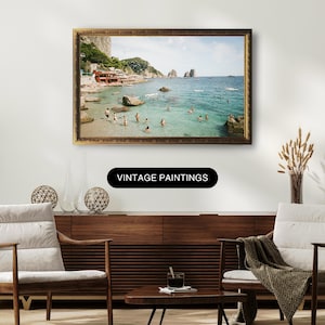 May include: A vintage photograph of a beach scene with people swimming in the ocean. The photo is framed in a gold frame and is hanging on a wall. The text "Vintage Paintings" is displayed below the frame.