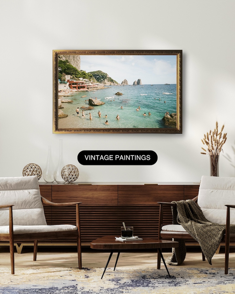 May include: A vintage photograph of a beach scene with people swimming in the ocean. The photo is framed in a gold frame and is hanging on a wall. The text "Vintage Paintings" is displayed below the frame.