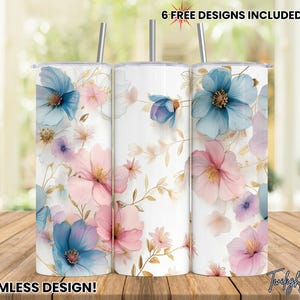 May include: Three stainless steel tumblers with a floral design. The tumblers feature a white background with pink, blue, and purple flowers. The text "6 FREE DESIGNS INCLUDED!" is at the top of the image. The text "SEAMLESS DESIGN!" is at the bottom of the image.