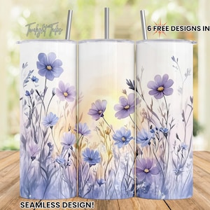 May include: Three white stainless steel tumblers with floral designs. The tumblers feature a seamless design of purple and blue flowers with green stems. Each tumbler has a silver straw and the text "6 FREE DESIGNS INCLUDED!"