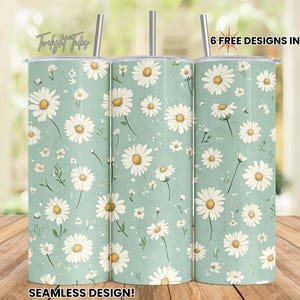 May include: Three stainless steel tumblers with a seamless design featuring a white daisy pattern on a light blue background.  The tumblers are shown on a wooden surface.