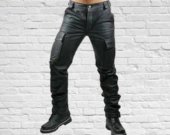 May include: Black leather cargo pants with two side pockets and a button closure. The pants have a classic design and are paired with black leather boots. The pants are made of a smooth, shiny material.