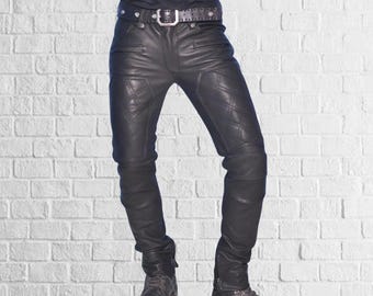 May include: Black leather pants with diamond-stitched detailing. The pants have a belt with a silver buckle and are worn with black boots. The pants have a slim fit and feature zippered pockets.