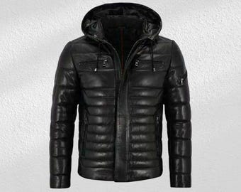 May include: Black leather hooded jacket with a quilted design. The jacket features a full-length zipper, multiple pockets, and a drawstring hood. The jacket is designed for warmth and style.