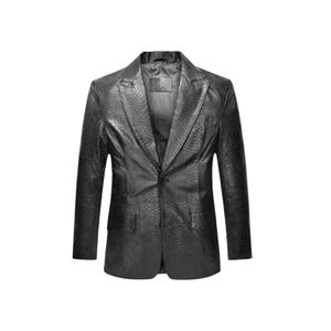 May include: A black blazer featuring a textured snakeskin pattern throughout the fabric. The garment includes a notched lapel, a single-button front closure, and two flap pockets on the lower front. The interior is lined with a smooth black fabric.