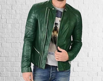 May include: A dark green leather jacket with a zipper closure and a stand-up collar. The jacket has a quilted design on the shoulders and a slim fit. The person is wearing a gray t-shirt and blue jeans.