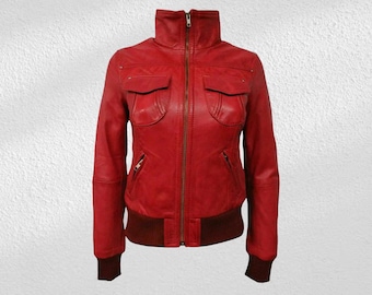 Puede incluir: Chaqueta de cuero roja brillante con cuello alto y cremallera completa. La chaqueta tiene dos bolsillos delanteros, dobladillo y puños acanalados. El diseño es de estilo bomber clásico.