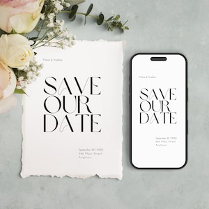 Könnte beinhalten: Eine weiße Save-the-Date-Karte mit schwarzem Text, der "Save Our Date" lautet, mit dem Datum "September 22/2023" und der Adresse "246 Main Street Anytown". Ein schwarzes Smartphone mit weißem Bildschirm zeigt denselben Text und dieselben Informationen an.