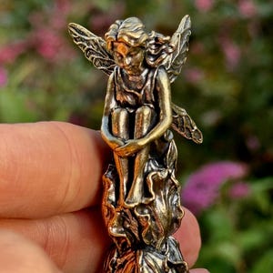 Mässingsälva i lövklänning, sittande skogsälva med vingar