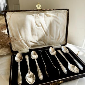 Antique EPNS Silver Plated Teaspoon Set in Ornate Faux-Croc Box – 7 Pieces with Sugar Tongs