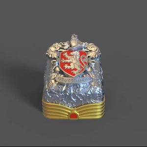 May include: A silver-coloured, rectangular box with a gold base and a red accent. The box features the Gryffindor crest, including a red shield with a lion, and the word "Gryffindor". The box has ornate detailing.