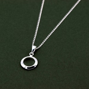 May include: A silver chain necklace with a simple circle pendant. The pendant is smooth and has a slightly raised edge.