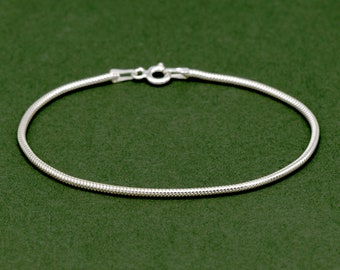May include: A silver snake chain bracelet with a lobster clasp closure.