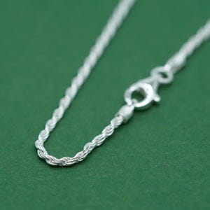 May include: A silver rope chain necklace with a lobster clasp.