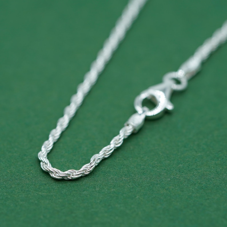 May include: A silver rope chain necklace with a lobster clasp.
