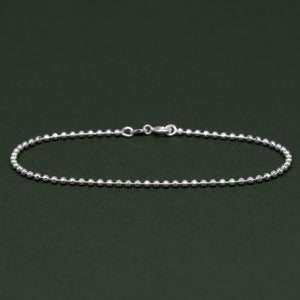 May include: A silver chain bracelet with a delicate ball chain design.