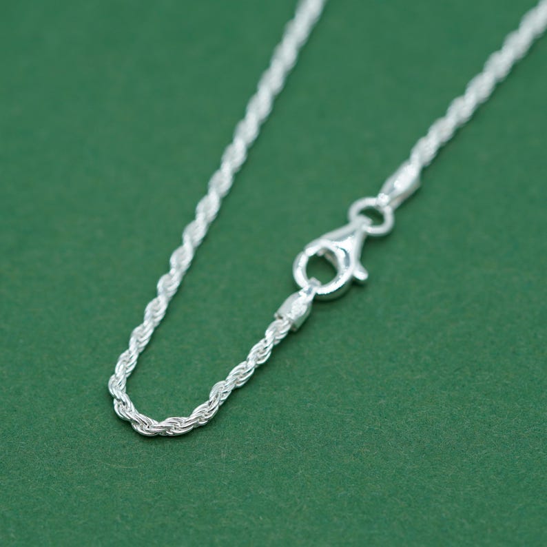May include: A silver rope chain necklace with a lobster clasp closure.