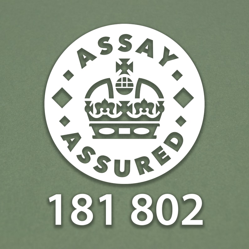 May include: White circle with the text "Assay Assured" and a crown inside. The number 181 802 is below the circle.