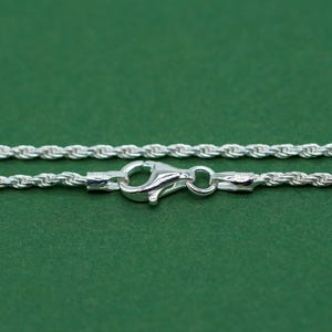 May include: A silver rope chain necklace with a lobster clasp closure.