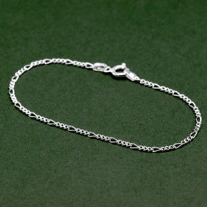 May include: A silver chain bracelet with a lobster clasp.