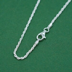 May include: A silver rope chain necklace with a lobster clasp closure.