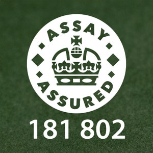 Pode incluir: C&iacute;rculo branco com o texto "Assay Assured" e uma coroa dentro. O n&uacute;mero 181 802 est&aacute; abaixo do c&iacute;rculo.