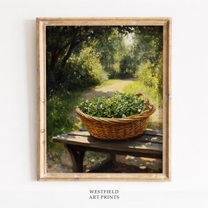 May include: A framed art print depicts a rustic scene. A woven basket filled with green foliage sits on a wooden bench. A path winds through a sunlit forest, with the text "WESTFIELD ART PRINTS" at the bottom.