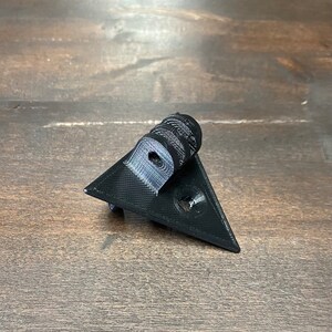 May include: A black 3D printed triangular camera mount with a GoPro-style mount on top.