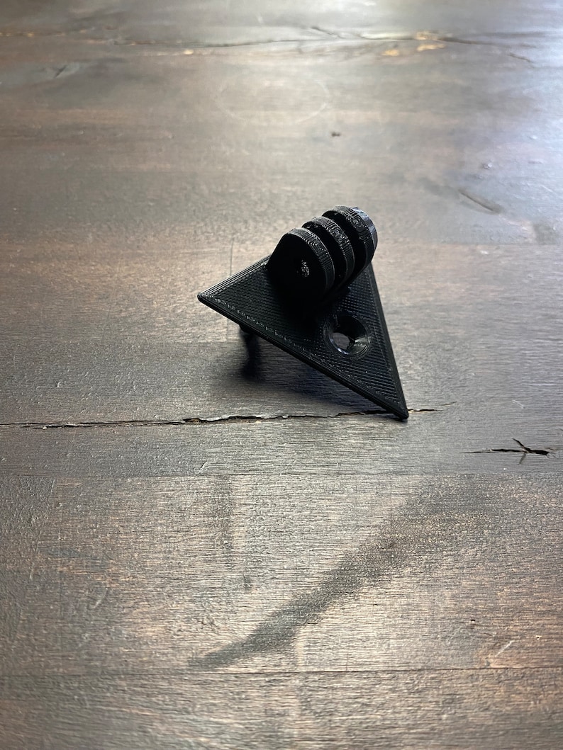 May include: Black plastic triangular camera mount with a GoPro-style mount on top.