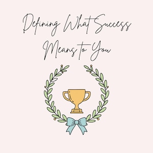 May include: A digital art print on a light pink background. The text reads "Defining What Success Means to You" in black script. A gold trophy is centered within a green laurel wreath, with a light blue bow below.