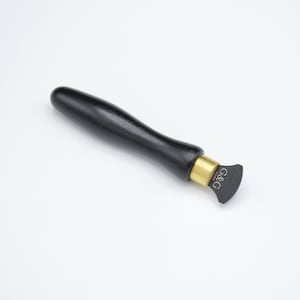 Pode incluir: Uma ferramenta com cabo de madeira preto, uma banda de metal dourado e uma lâmina preta com ponta arredondada. A lâmina é etiquetada com "G&G Tools".