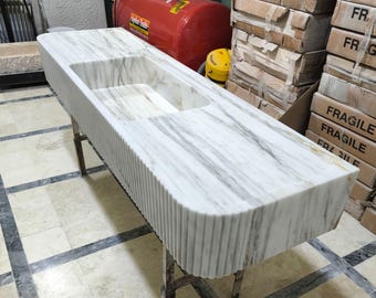 Lavabo da appoggio in marmo di Carrara intagliato a mano: frontale scanalato, angoli arrotondati.