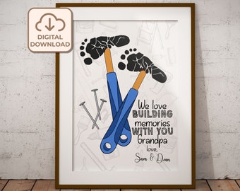 Op de afbeelding: Een afdrukbare kunstprint met een witte achtergrond en een zwart-blauwe illustratie van twee voetafdrukken met een hamer en spijkers. De tekst luidt "We love building memories with you Grandpa, love, Sam & Dean".