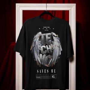 Puede incluir: Camiseta negra con un estampado gráfico de una palabra "techno" plateada con alas. El texto "When the world fails me Techno saves me" está impreso sobre el gráfico. El año "1990" está impreso debajo del gráfico.