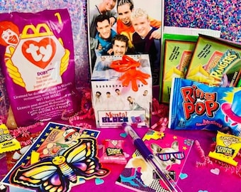 May include: A collection of 90s-themed items including a McDonald's Ty Doby toy bag, a Backstreet Boys Mental Block puzzle, Power Rangers trading cards, a blue raspberry Ring Pop, Extreme Sour candies, a butterfly sticker, and temporary tattoos.