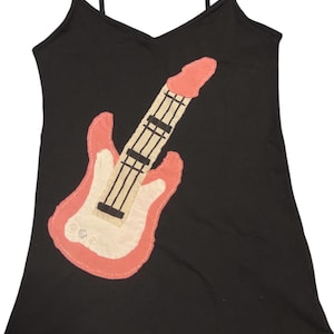 Könnte beinhalten: Schwarzes Spaghettiträger-Top mit einem Applikation einer rosa und weißen Gitarre. Das Gitarrendesign hat einen rosa Umriss, einen weißen Korpus und schwarze Saiten. Das Top hat einen V-Ausschnitt.