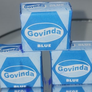 May include: Three blue cubes with the word "Govinda" and "BLUE" printed on them. The cubes are stacked on top of each other.