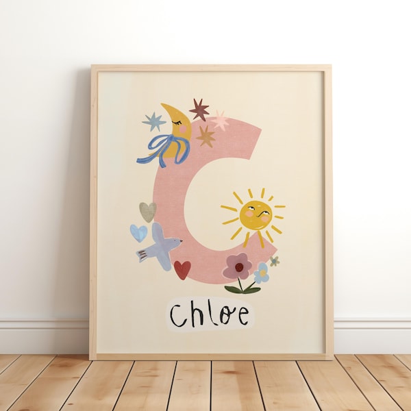 Puede incluir: Una lámina decorativa enmarcada con una letra C grande de color rosa claro decorada con una luna creciente amarilla, un sol sonriente, un pájaro azul, corazones, estrellas y flores. El nombre Chloe aparece en letras negras estilo manuscrito.